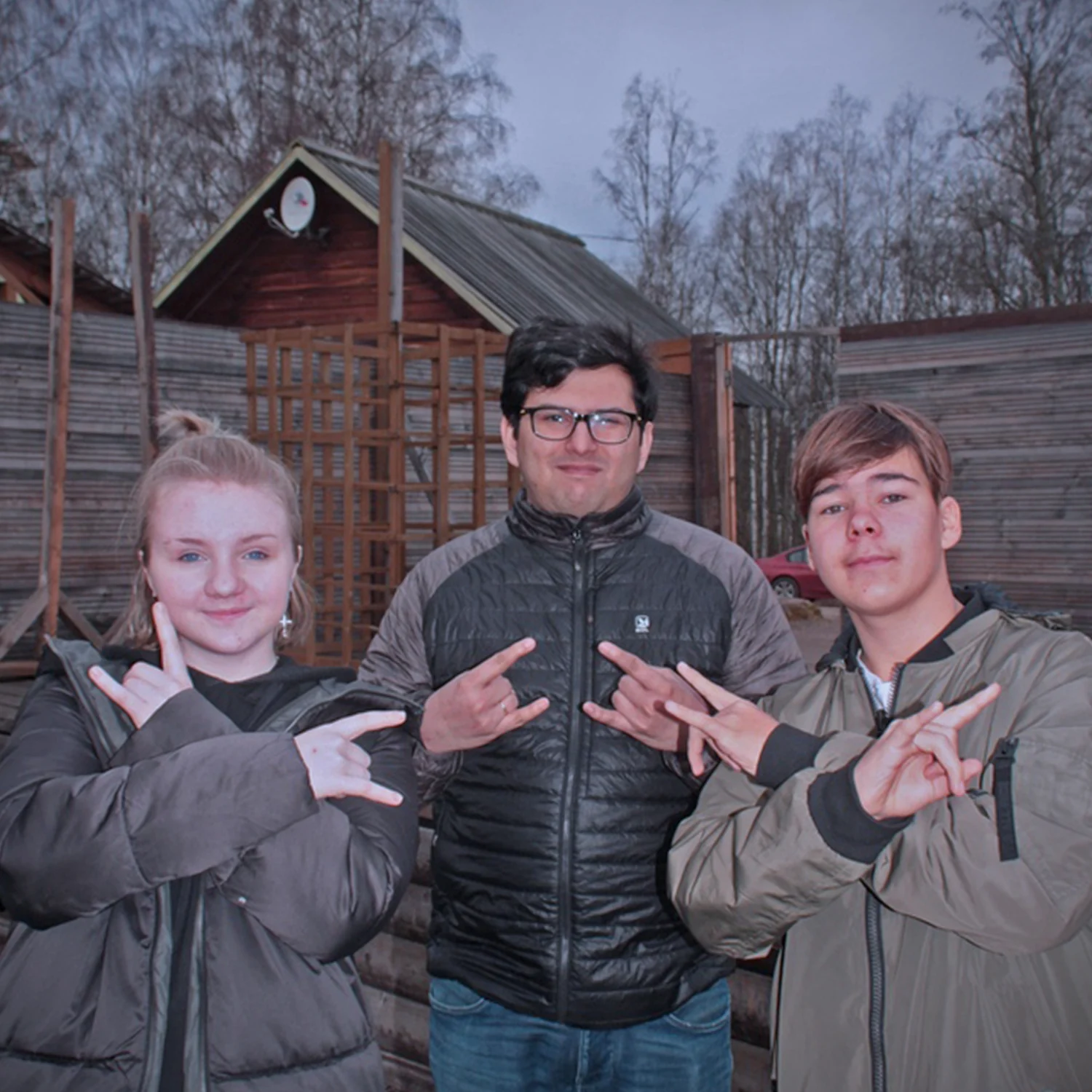 Ronnie and two young people posing outdoors in winter jackets