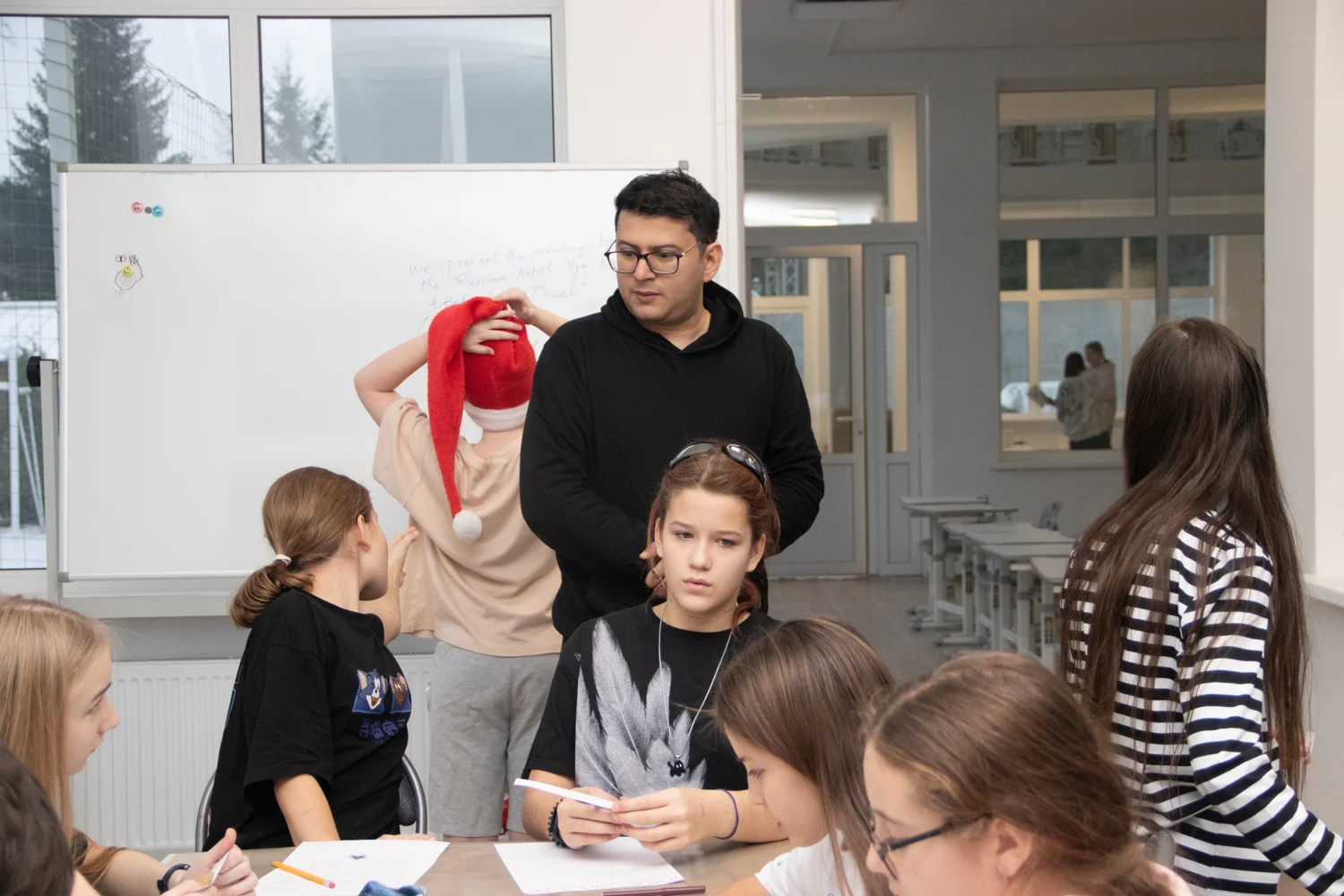 Ronnie working with young learners around a classroom table at Varnavskii Camp